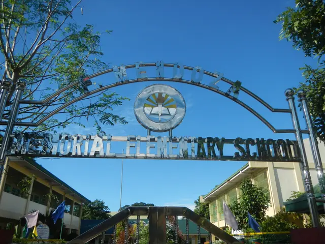 The image shows the entrance to a memorial elementary school, with an arch in the foreground...
