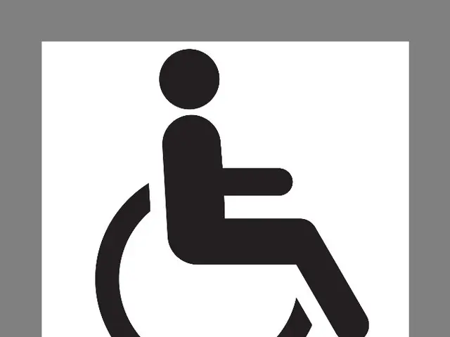 The image shows a black and white sign with a person in a wheelchair, set against a gray...