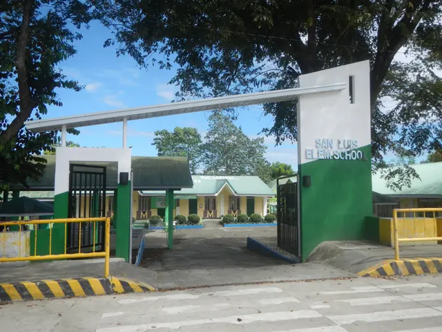 The image shows the entrance to San Luis Elementary School in the Philippines, with a road at the...