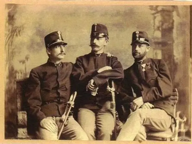 The image shows three men in military uniforms sitting next to each other, wearing caps and holding...