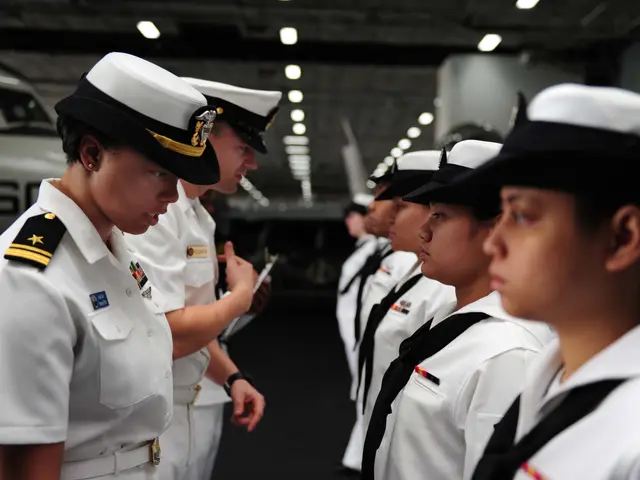 The image shows a group of women in white uniforms standing next to each other, wearing caps and...