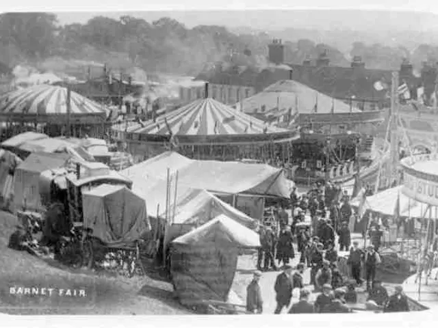 The image shows an old black and white photo of a carnival with tents, people, carts, poles, trees,...