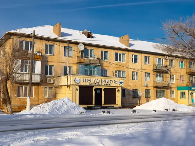 The image shows a large building with windows, doors, railings, dish antennas and a name board,...