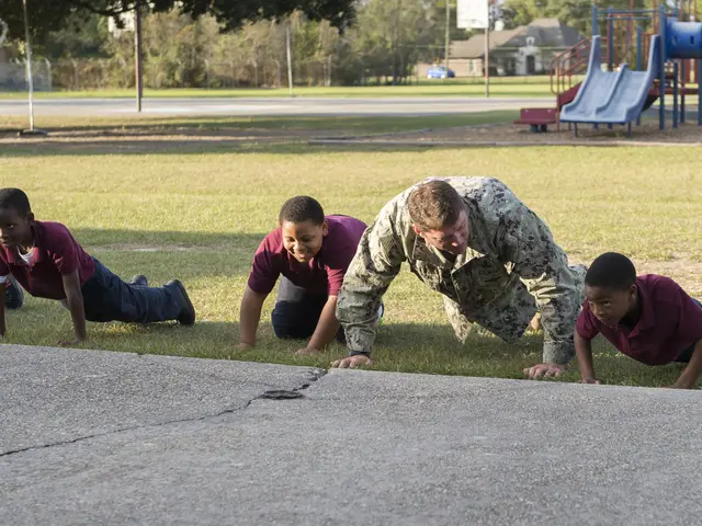 The image shows a group of children doing push ups in a park, surrounded by grass, a pathway,...