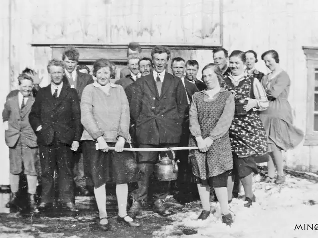 The image shows a group of people standing next to each other in front of a building, smiling and...