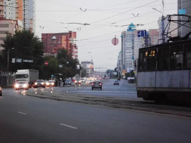 The image shows a city street filled with lots of traffic, including a bus, truck, and street...