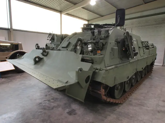 The image shows a military vehicle parked inside of a building, with a board with text on it, a...