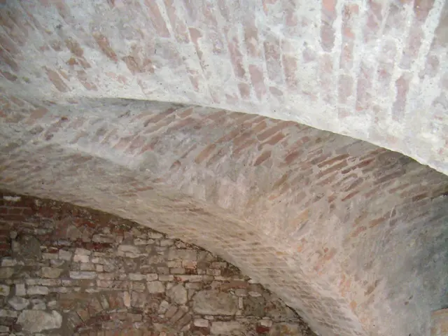 The image shows an old brick building with a vaulted ceiling and a tiled floor. The walls are made...