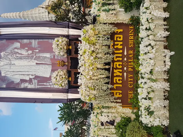The image shows the grand palace in Bangkok, Thailand, decorated with white flowers and greenery....