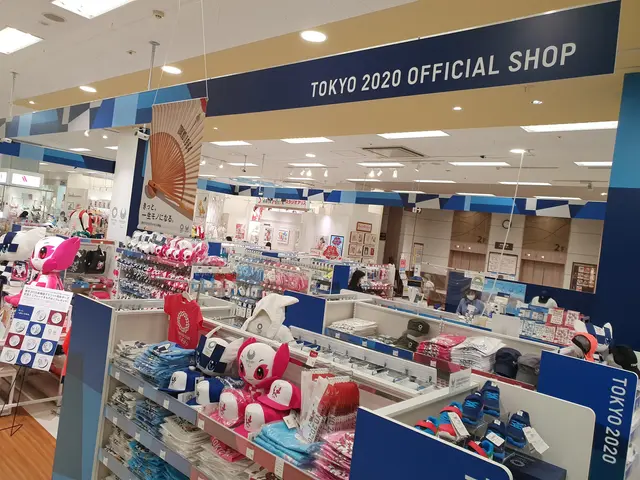The image shows a Tokyo 2020 Official Shop, with a variety of items on the racks, including...