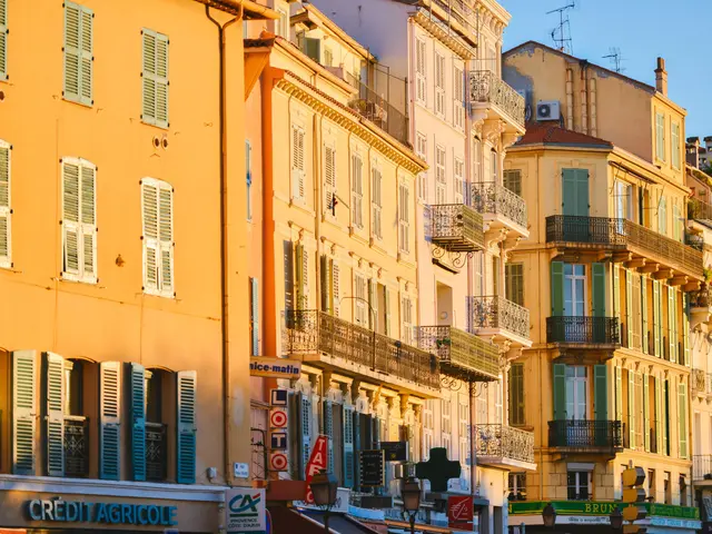 The image shows a city street filled with lots of tall buildings with windows, railings, balconies,...
